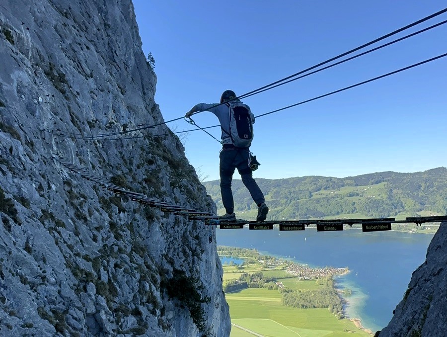 Crossing a suspended via ferrata bridge high above the valley floor